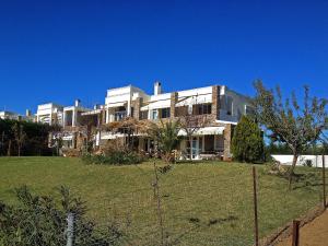 a large white house on top of a field at Lovely apartm.near airport in Kardiá