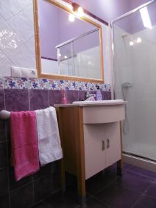 een badkamer met een wastafel, een spiegel en een douche bij Casa Benito in Ribadeo