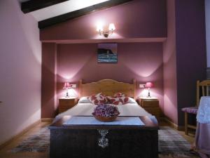 1 dormitorio con 1 cama grande y paredes moradas en Casa Benito en Ribadeo