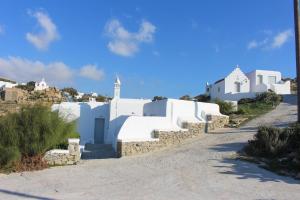 a row of white buildings on a dirt road at Crystal View Mykonos in Mikonos