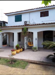 una casa blanca con plantas delante en Las Palmitas, en Atlántida