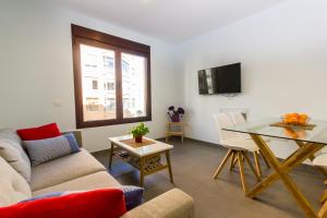 ein Wohnzimmer mit Sofa und Tisch in der Unterkunft Canteras Luxury Beach Apartments in Las Palmas de Gran Canaria