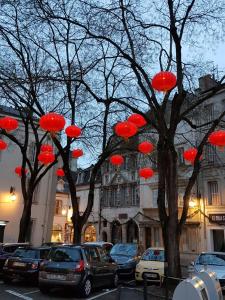 um grupo de guarda-chuvas vermelhos pendurados nas árvores em Hôtel Montchapet Dijon Centre em Dijon