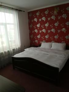 a bedroom with a large bed with a red wall at Select in Bistriţa