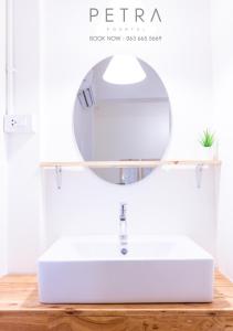 La salle de bains est pourvue d'un lavabo blanc et d'un miroir. dans l'établissement Petra Poshtel Donmuang, à Bangkok