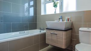 Ur City Pad - 4 bedrooms - 4 bathrooms - Somerset House في برمنغهام: حمام مع حوض وحوض استحمام ومرحاض