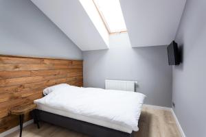 シュチルクにあるApartament DOMANI z widokiem na góryの木製の壁のベッドルーム1室(ベッド1台付)