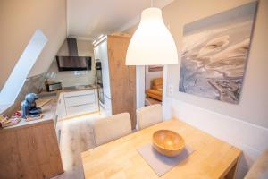 a kitchen and dining room with a wooden table in a room at Ferienwohnungen Hofmann in Zingst