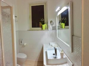 La salle de bains blanche est pourvue d'un lavabo et de toilettes. dans l'établissement casa Tolinda 2, à Bolsena