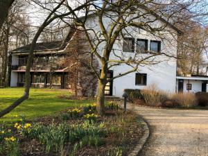 una casa blanca con un árbol delante en Villa am Hülser Berg nähe Düsseldorf, en Krefeld
