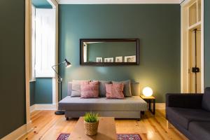 a living room with a couch and a mirror at Glória by Central Hill Apartments in Lisbon