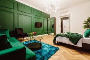 クラクフにあるKings City - Blich Apartmentの緑豊かなリビングルーム(ベッド1台、ソファ付)