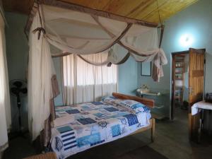 a bedroom with a canopy bed and a window at Gateway Guest House in Monkey Bay