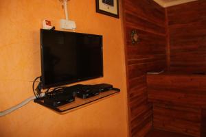 a flat screen tv hanging on a wall at Saltek Forest Cottages in Masindi