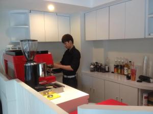 a man standing in a kitchen with a red mixer at Delight Residence in Bangkok