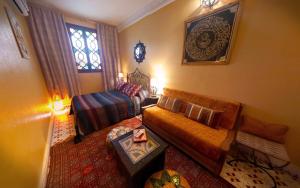 a living room with a couch and a bed and a window at Riad Atika Mek in Meknès