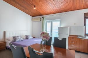 a room with a table and a bed and a kitchen at Beach Guesthouse Mediteran in Podstrana