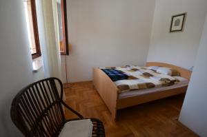 - une chambre avec un lit et une chaise dans l'établissement Apartments Villa Bartol, à Pula