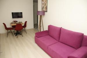 un sofá púrpura en una sala de estar con mesa en Pera Colour House, en Estambul