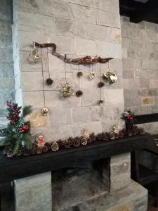 a fireplace with christmas decorations on a stone wall at Complex Magic of the Rhodopes in Bachkovo