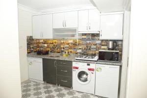cocina con armarios blancos, lavadora y secadora en Pera Colour House, en Estambul
