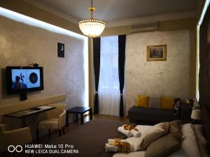 a room with a bed and a couch and a tv at Knez Mihailova Apartman in Belgrade
