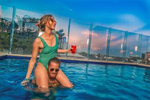 a woman and a boy in a swimming pool at Nomads Hotel & Rooftop Pool Cancun in Cancún
