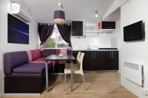 a kitchen and a living room with a table and a couch at Amadria Park Camping Sibenik Mobile Homes in Šibenik