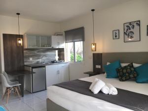 a bedroom with a large bed and a kitchen at Studios Katerina in Iraklitsa