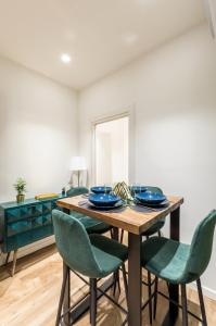 une salle à manger avec une table en bois et des chaises vertes dans l'établissement Lovely Rome Apartments - Ghetto, à Rome