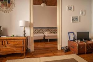una sala de estar con una maleta y un sofá en The Blue House - Lively Bairro Alto en Lisboa