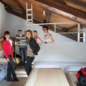 people standing around a bunk bed at Hostel California in Milan