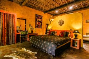 a bedroom with a bed and a table and a chair at Kwalucia Private Safari Retreat in St Lucia