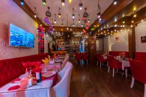 um restaurante com mesas brancas e cadeiras vermelhas em Charm Hotel em Istambul