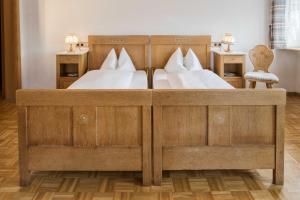 a bedroom with two beds and a chair at Gasthaus Kranz Bonndorf in Bonndorf im Schwarzwald +2 photos