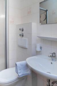 a white bathroom with a sink and a toilet at Gasthaus Kranz Bonndorf in Bonndorf im Schwarzwald