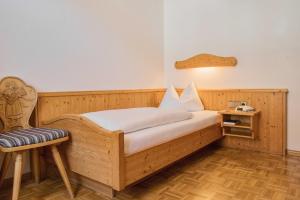 a bedroom with a wooden bed and a chair at Gasthaus Kranz Bonndorf in Bonndorf im Schwarzwald