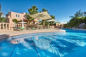 une grande piscine avec un parasol et des chaises dans l'établissement Villa Ruly, à San José