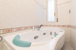 a white bath tub with a blue seat in a bathroom at Cappuccini Florence your easy stay close to the center in Florence +43 photos