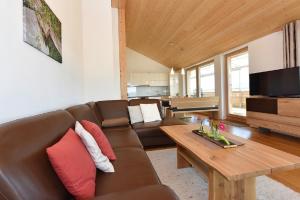 salon z brązową kanapą i drewnianym stołem w obiekcie Ferienhof Feurle w mieście Sulzberg