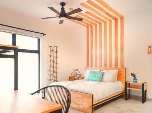 Nomads Hotel, Hostel & Rooftop Pool Cancun في كانكون: غرفة نوم مع سرير ومروحة سقف