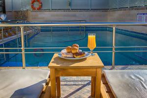 a table with a plate of food and a glass of orange juice at Anthena Studios in Skiathos