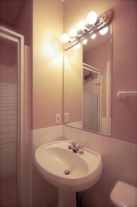 y baño con lavabo y espejo. en Hotel Auberge Michel Doyon, en Quebec