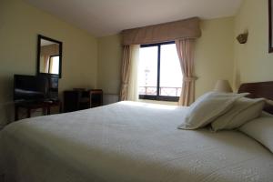 Un pat sau paturi într-o cameră la Hotel La Serena Plaza