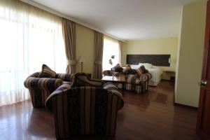 a hotel room with couches and a bed at Hotel La Serena Plaza in La Serena