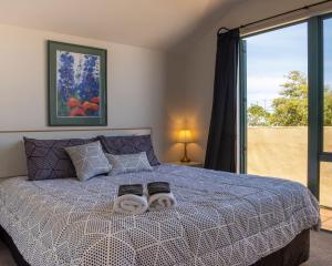 a bedroom with a bed with two towels on it at Tuscany Gardens Motor Lodge in Nelson