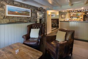 un bar con 2 sillas de cuero y una mesa en The Cambrian Inn en Solva