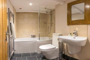 a bathroom with a toilet and a sink and a tub at The Cambrian Inn in Solva