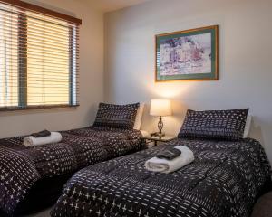 a bedroom with two beds and a lamp at Tuscany Gardens Motor Lodge in Nelson +19 photos