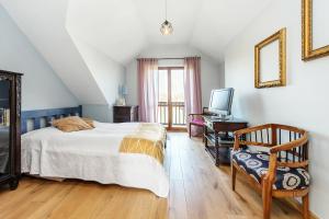 1 dormitorio con 1 cama, TV y silla en Dom w Grodzisku en Skała